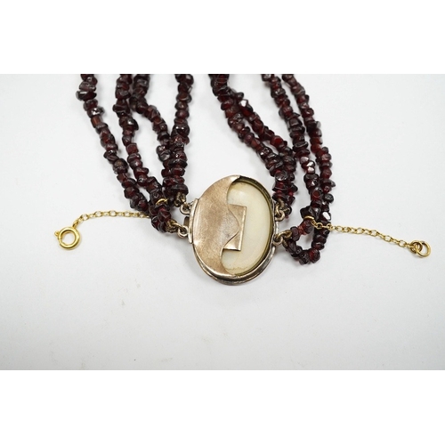 932 - A late 19th/early 20th century multi strand rough cut garnet set necklace, with a yellow metal mount... 