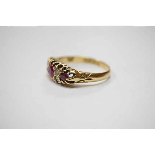 937 - A George V 18ct gold and three stone ruby set half hoop ring, with diamond chip spacers, (one stone ... 