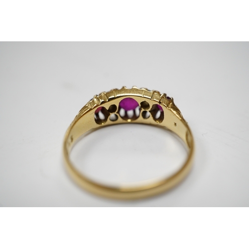 937 - A George V 18ct gold and three stone ruby set half hoop ring, with diamond chip spacers, (one stone ... 