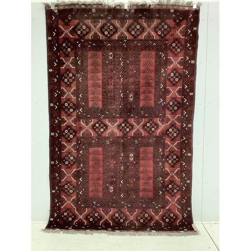 1002 - A Belouch red ground carpet, approximately 250cm x 160cm. Condition - fair to good