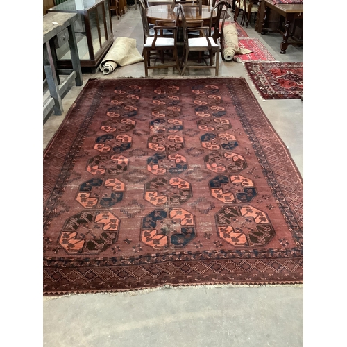 1005 - An Afghan red ground carpet, 380 x 240cm. Condition - poor to fair, one area of patching and several... 