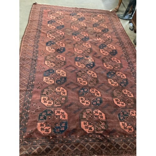 1005 - An Afghan red ground carpet, 380 x 240cm. Condition - poor to fair, one area of patching and several... 