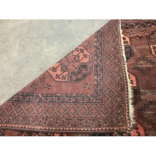 1005 - An Afghan red ground carpet, 380 x 240cm. Condition - poor to fair, one area of patching and several... 