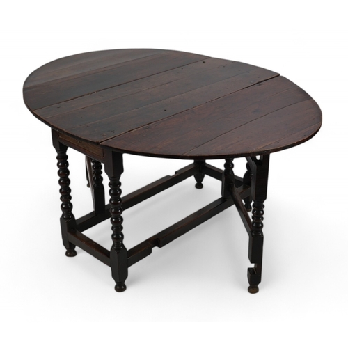 1039 - A 17th century and later oak gateleg table, with oval drop leaf top and single frieze drawer, on bob... 