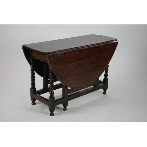 1039 - A 17th century and later oak gateleg table, with oval drop leaf top and single frieze drawer, on bob... 