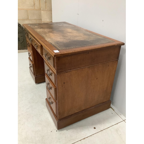 1050 - An early 20th century oak pedestal desk, fitted nine drawers, with a leather inset top, width 121cm,... 