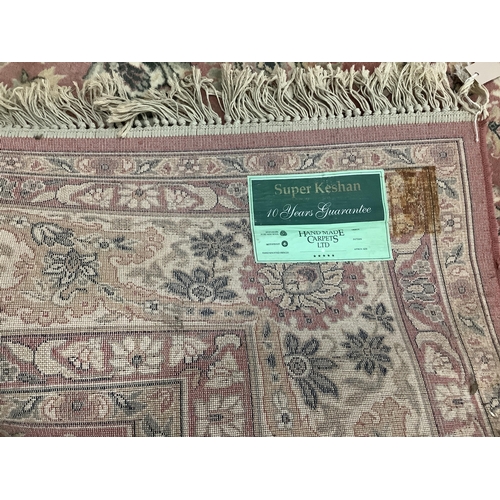 1064 - A Kashan style peach ground machined carpet, 360 x 274cm. Condition - fair to good, will require cle... 