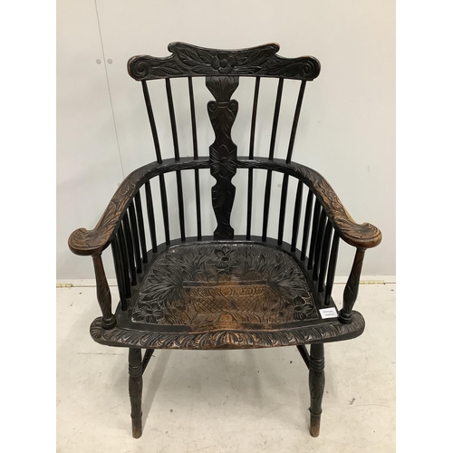 1072 - A 19th century Windsor comb back elbow chair, later stained and carved, width 69cm, depth 45cm, heig... 