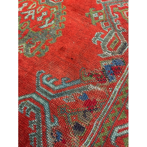 1158 - A large Turkish carpet, with triple row of stylised medallions on a red ground, multi bordered, 413 ... 