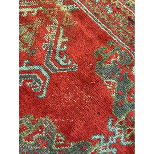 1158 - A large Turkish carpet, with triple row of stylised medallions on a red ground, multi bordered, 413 ... 