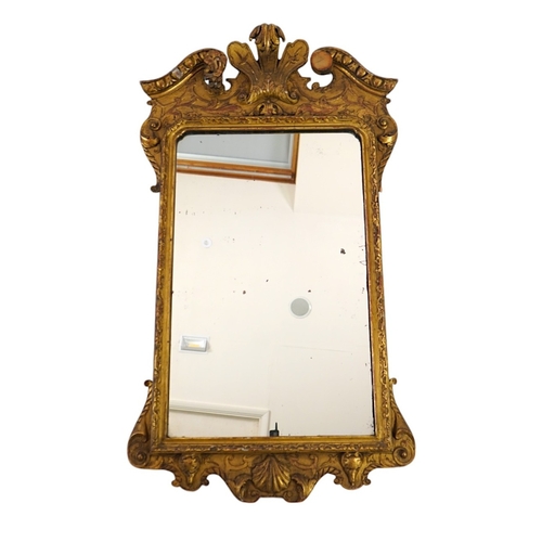 1175 - A George III style giltwood wall mirror, of architectural form with foliate scroll broken arch crest... 