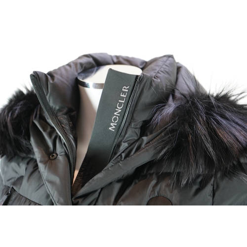 1242 - A lady's Moncler Grenoble down black ski jacket with fur trimmed hood and belted waist. UK size 10... 