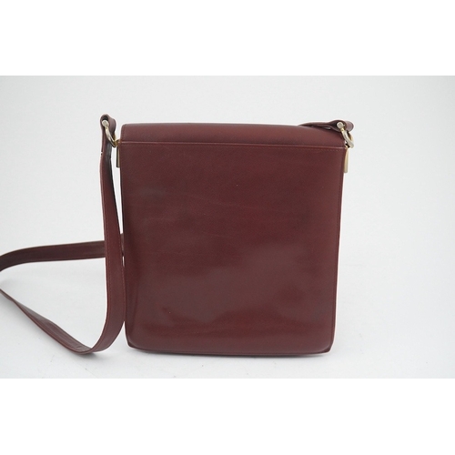 1251 - A Must de Cartier lady's leather shoulder bag in bordeaux, with dust bag