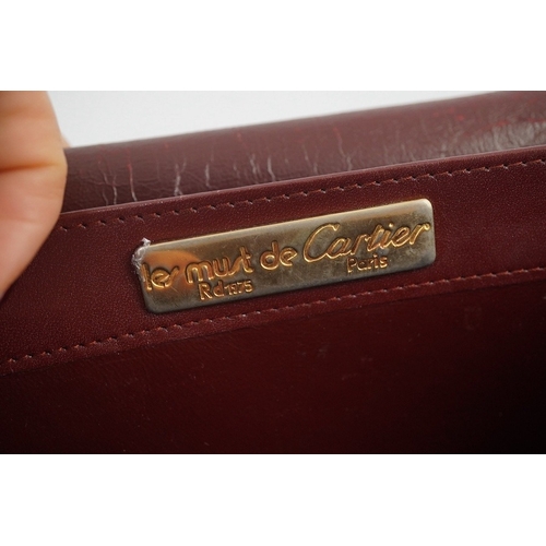 1251 - A Must de Cartier lady's leather shoulder bag in bordeaux, with dust bag