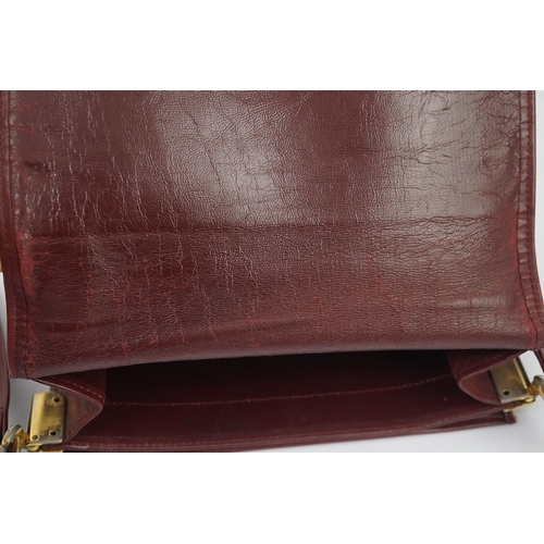 1251 - A Must de Cartier lady's leather shoulder bag in bordeaux, with dust bag