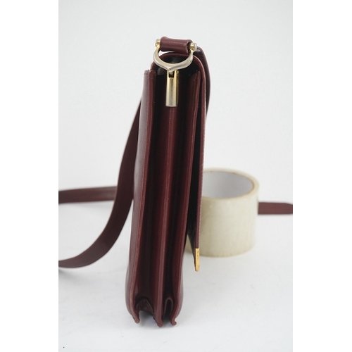 1251 - A Must de Cartier lady's leather shoulder bag in bordeaux, with dust bag