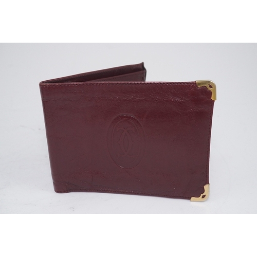 1252 - An assortment of Must de Cartier bordeaux leather accessories including small coin purse, two wallet... 