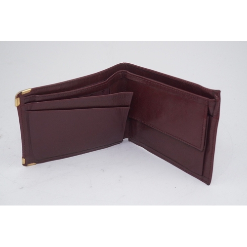 1252 - An assortment of Must de Cartier bordeaux leather accessories including small coin purse, two wallet... 