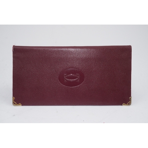 1252 - An assortment of Must de Cartier bordeaux leather accessories including small coin purse, two wallet... 