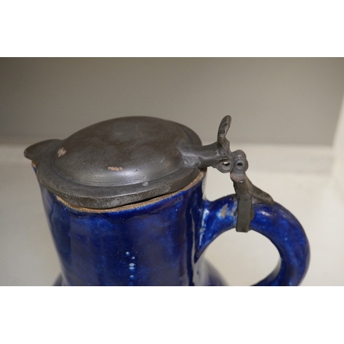 1313 - An 18th century German blue glazed faience jug with pewter lid, 30cm. Conditon - poor to fair