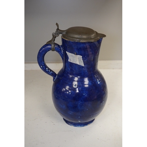 1313 - An 18th century German blue glazed faience jug with pewter lid, 30cm. Conditon - poor to fair