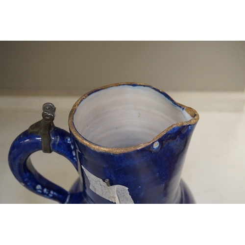 1313 - An 18th century German blue glazed faience jug with pewter lid, 30cm. Conditon - poor to fair