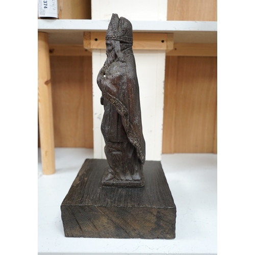 1372 - A North European oak carving of a bishop, possibly 17th/18th century, 38cm high not including stand.... 