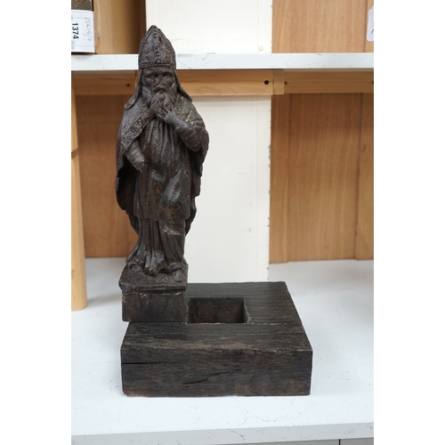 1372 - A North European oak carving of a bishop, possibly 17th/18th century, 38cm high not including stand.... 