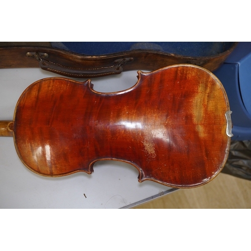 1417 - A late 19th century violin, bears fake Stradivarius label, cased, back measures 36cm. Condition - fa... 