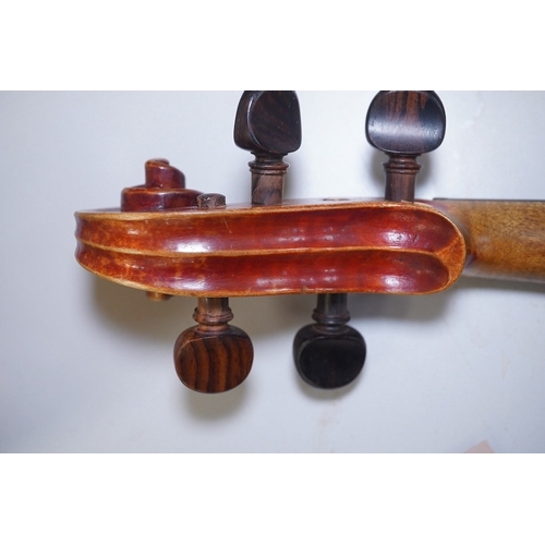 1417 - A late 19th century violin, bears fake Stradivarius label, cased, back measures 36cm. Condition - fa... 