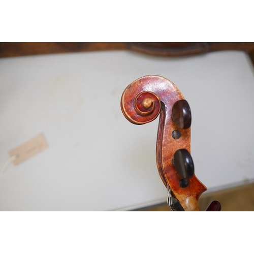 1417 - A late 19th century violin, bears fake Stradivarius label, cased, back measures 36cm. Condition - fa... 