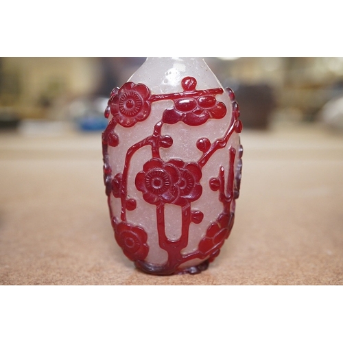 1426 - A Chinese cameo carved red overlaid on white snowflake ground snuff bottle and stopper, 19th century... 