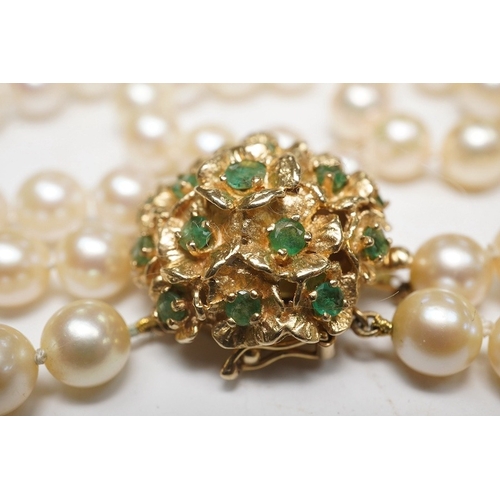 1906 - A modern triple strand culture pearl necklace, with emerald cluster set 14k clasp, 48cm. Condition -... 