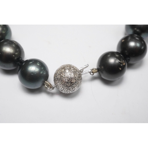 1907 - A modern single strand Tahitian black pearl necklace, with diamond cluster set 14k white metal spher... 