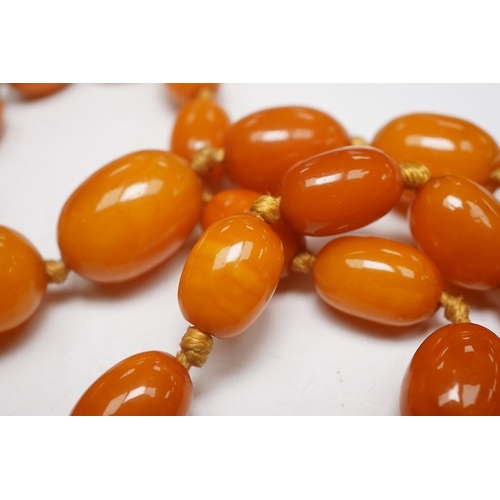 1914 - A single strand graduated oval amber bead necklace, 62cm, gross weight 34 grams. Condition - poor to... 