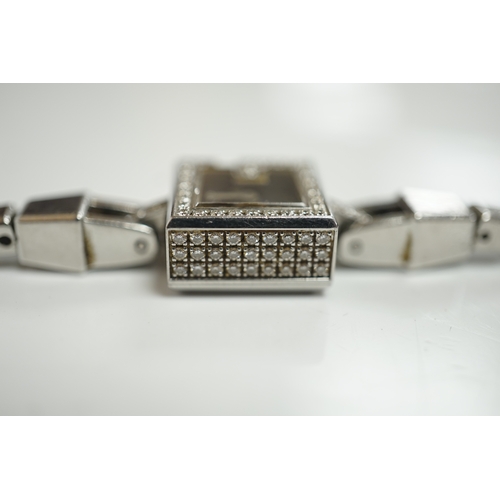 1915 - A lady's stainless steel Gucci quartz wrist watch, with G shaped case and diamond chip set bezel, on... 