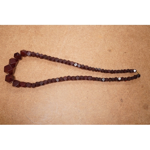 1917 - A single strand part facetted simulated cherry amber and part facet paste set necklace, (approx. 30 ... 