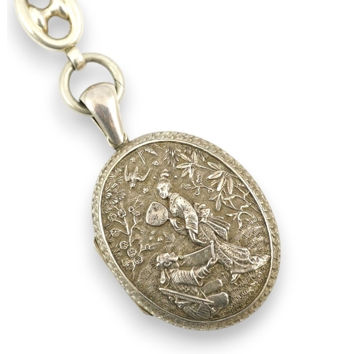 1926 - A late Victorian white metal oval locket with Japonaiserie decoration, 47mm, on a white metal chain.... 