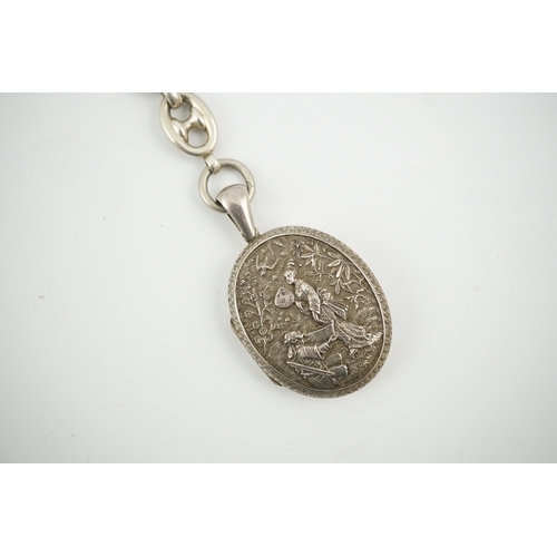 1926 - A late Victorian white metal oval locket with Japonaiserie decoration, 47mm, on a white metal chain.... 