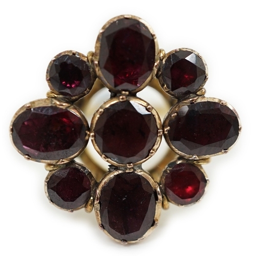 1927 - A late Victorian gold and nine stone garnet cluster set dress ring, of flower head design, set with ... 