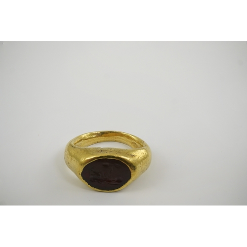 117 - A Roman gold and intaglio set ring, carved with a seated figure, shank misshapen, gross weight 9.5 g... 