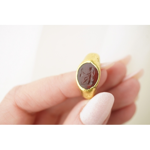 117 - A Roman gold and intaglio set ring, carved with a seated figure, shank misshapen, gross weight 9.5 g... 