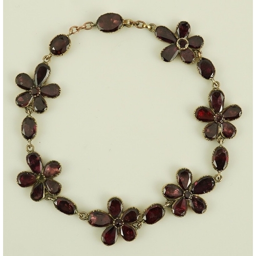 124 - An early Victorian gold and foil backed garnet cluster set bracelet, of foliate design, 17cm, gross ... 