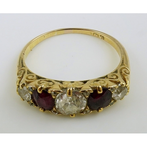 139 - A late Victorian 18ct gold, two stone ruby and three stone diamond set half hoop ring, with carved s... 