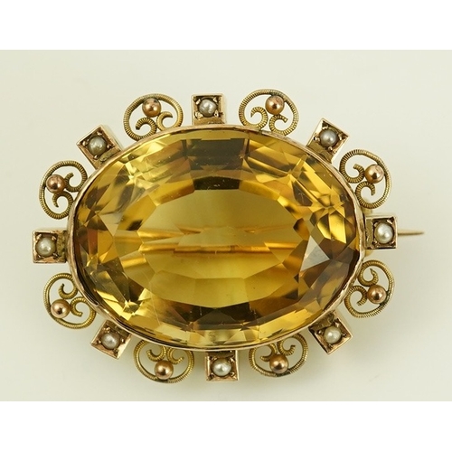 142 - A late Victorian 9ct gold, citrine and seed pearl cluster set oval brooch, with scroll and sphere bo... 