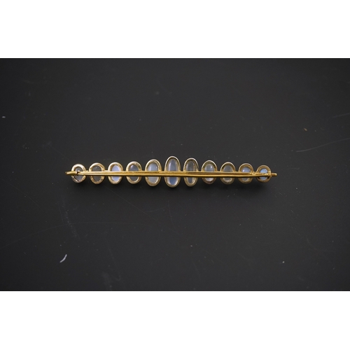 154 - A gold and eleven stone graduated cabochon moonstone set bar brooch, 89mm, gross weight 9.5 grams.... 