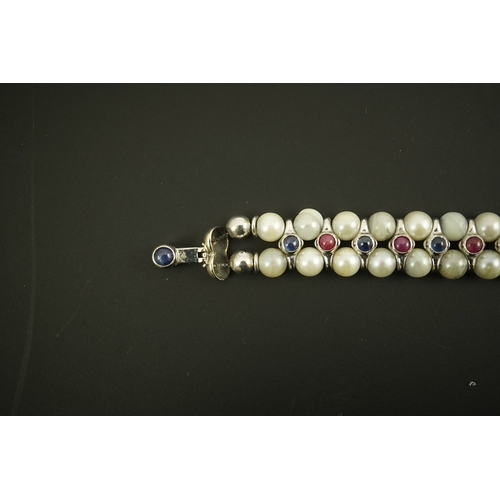 157 - A late 20th century 18k white gold and two row cultured pearl bracelet, set with single row of caboc... 