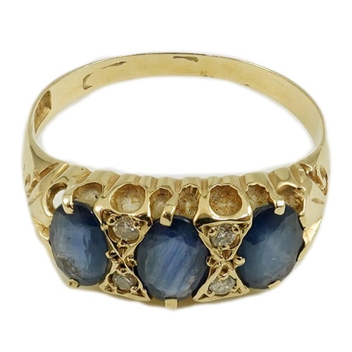 163 - An Edwardian 15ct gold and three stone oval cut sapphire set half hoop ring, with diamond chip space... 