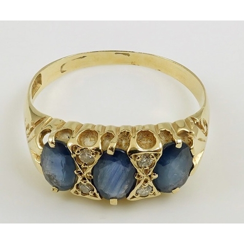 163 - An Edwardian 15ct gold and three stone oval cut sapphire set half hoop ring, with diamond chip space... 