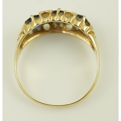 163 - An Edwardian 15ct gold and three stone oval cut sapphire set half hoop ring, with diamond chip space... 